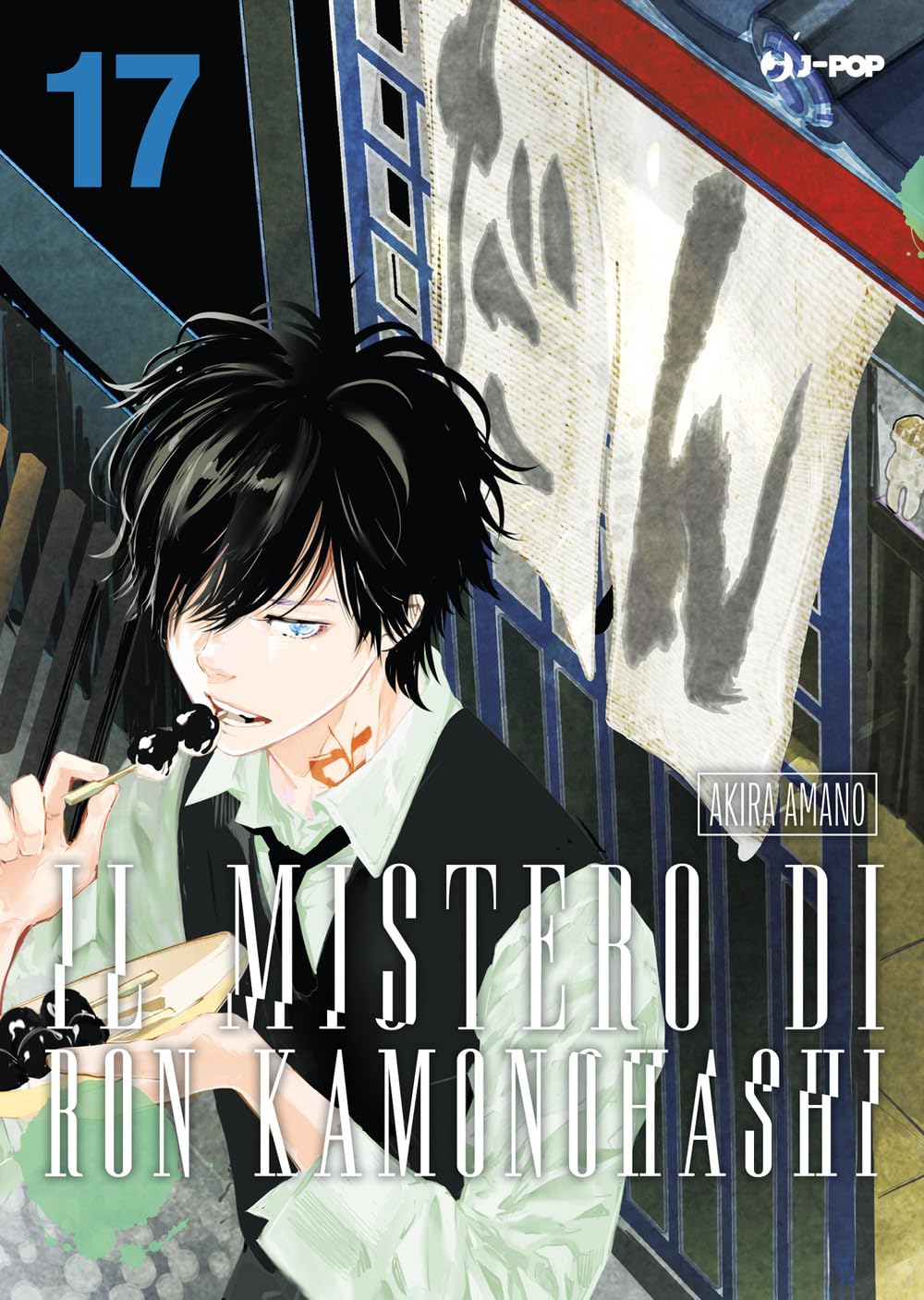 Copertina Il Mistero di Ron Kamonohashi 17. Ragazzo moro in gilet scuro che mangia dango neri da uno spiedino davanti a una bottega tradizionale.