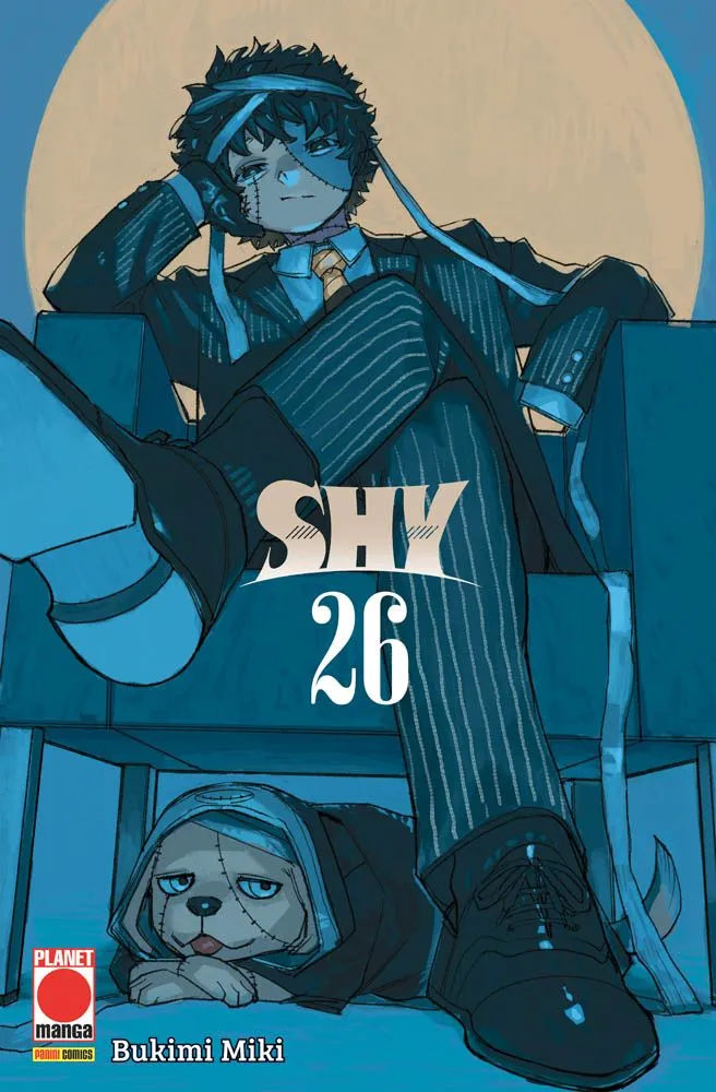 Copertina del manga Shy volume 26 edito da Planet Manga; l'illustrazione dai toni blu mostra un personaggio maschile bendato in abito elegante seduto su una poltrona, con un cane meccanico sotto di lui.