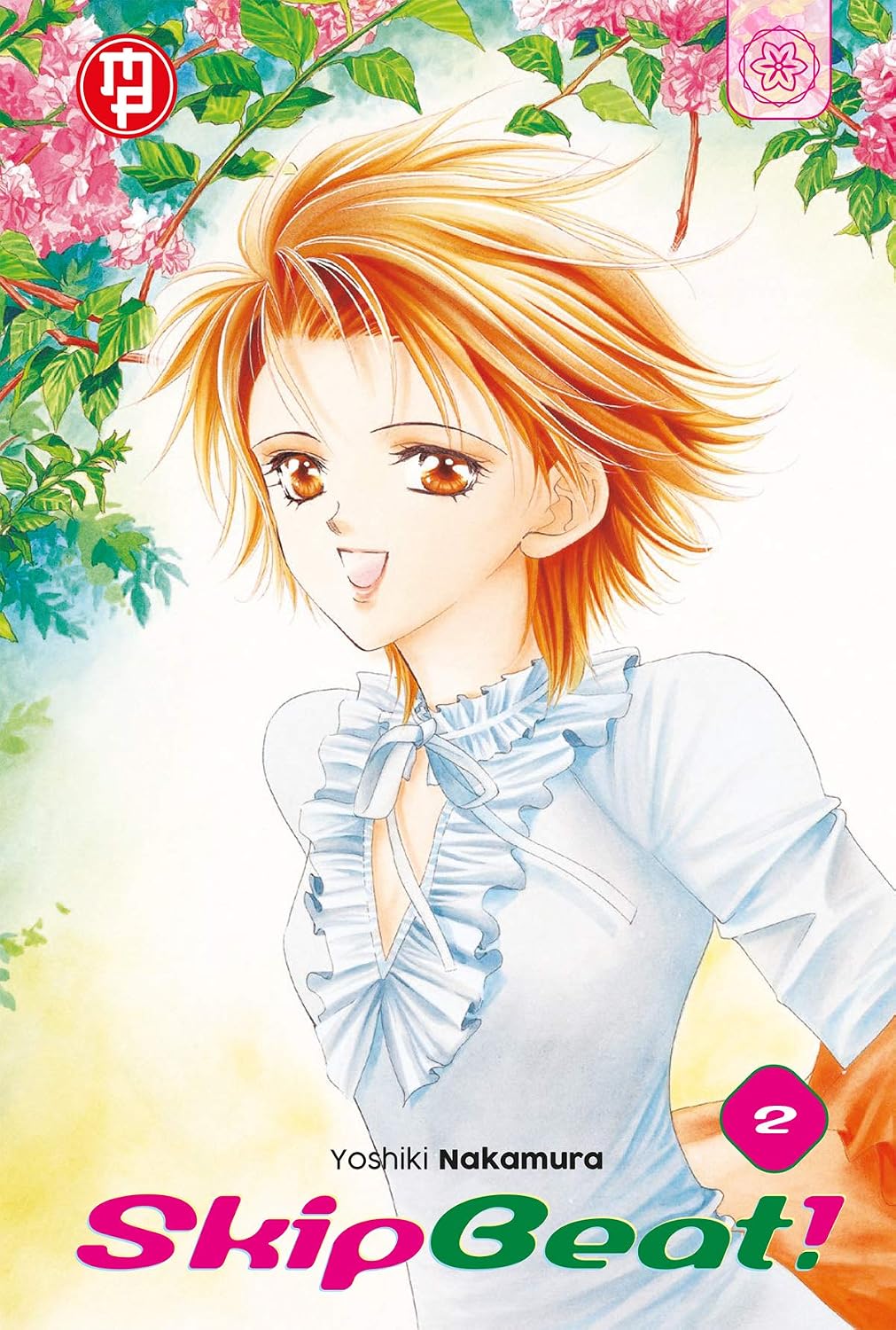 Copertina del secondo volume del manga 'Skip Beat!' di Yoshiki Nakamura, edito da Magic Press. L'illustrazione ritrae Kyoko Mogami sorridente con capelli arancioni corti sotto rami fioriti, affiancata dal numero 2 e dal titolo in basso.