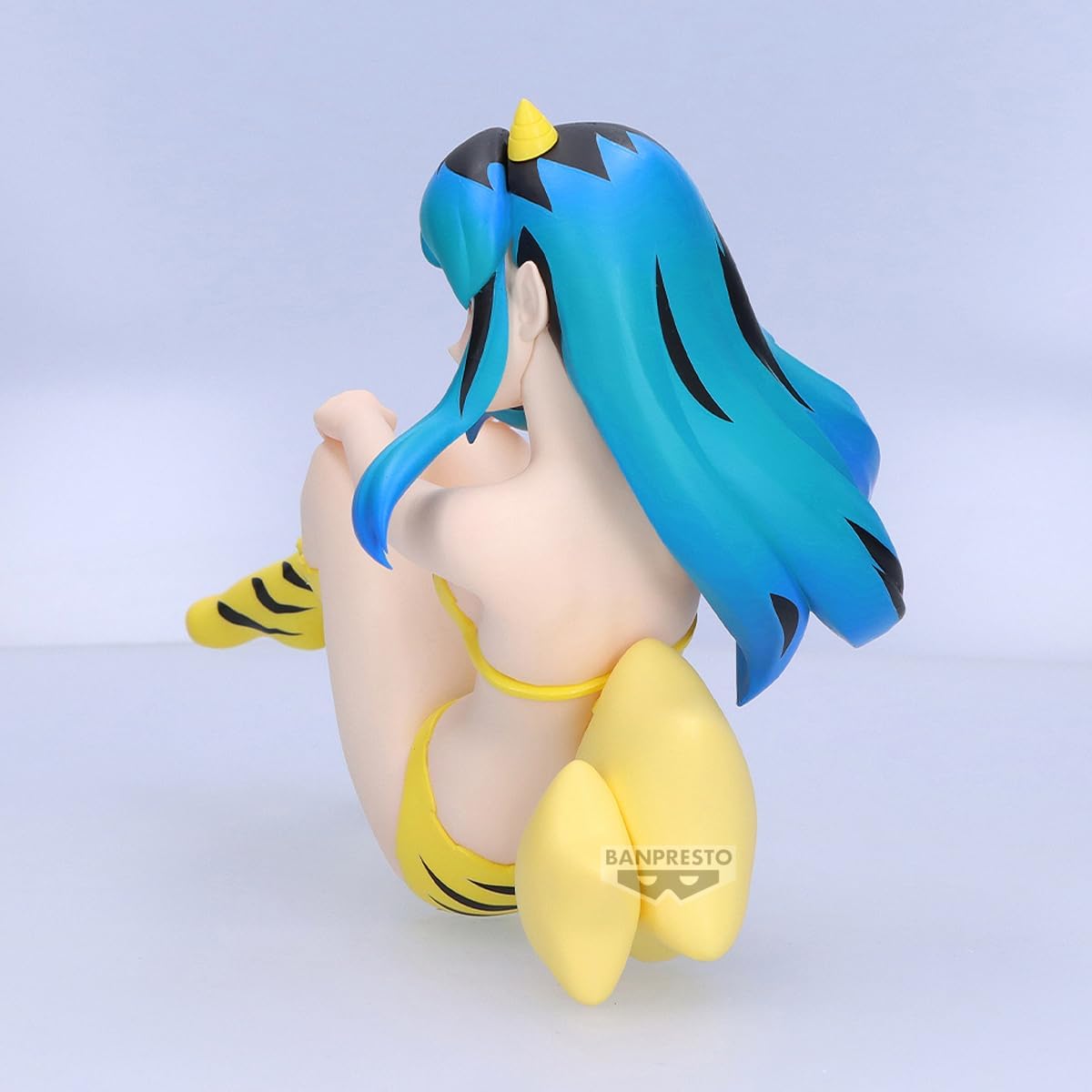 Figure di Lamù da Urusei Yatsura con il classico bikini tigrato e stivali alti, seduta in posa rilassata accanto a due stelle gialle.