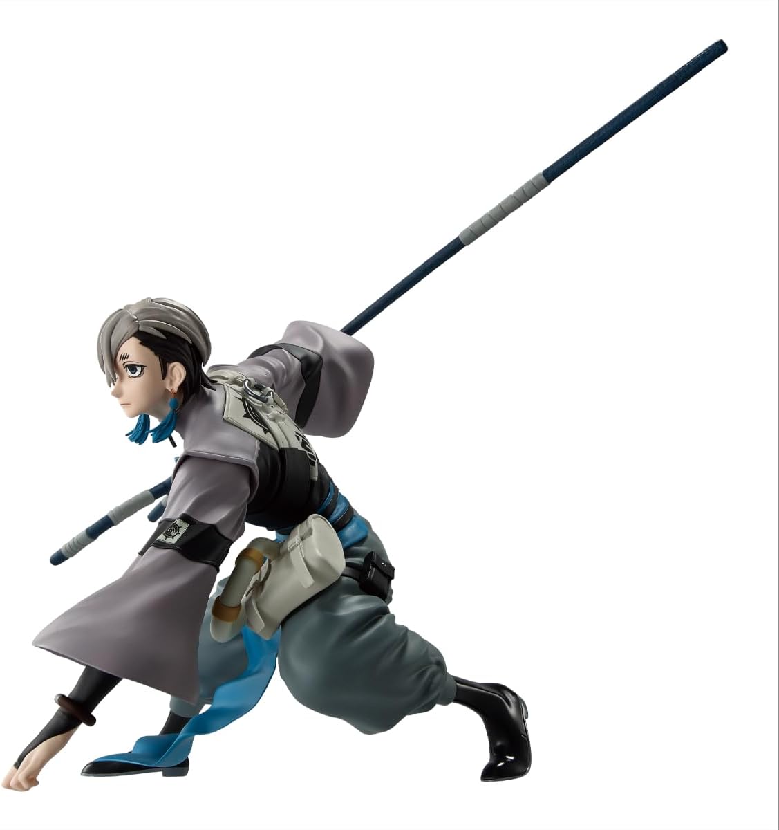 Figure da collezione della linea Vibration Stars raffigurante Zanka della serie manga e anime Gachiakuta, su sfondo bianco. Il personaggio è colto in una posa d'azione dinamica, accovacciato con la mano sinistra a terra mentre con la destra solleva all'indietro la sua arma a forma di bastone con punta a due rebbi. Indossa una casacca asimmetrica grigio chiaro con stemma sul petto, una fascia azzurra in vita, pantaloni larghi scuri e stivali neri. Il viso ha un'espressione seria e i capelli sono scuri ai lat