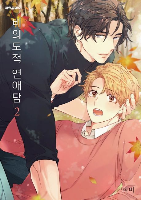 Copertina del secondo volume del manhwa Unintentional Love Story, che mostra in primo piano un ragazzo dai capelli scuri in maglia nera mentre cinge con cura da dietro un ragazzo biondo con un maglione rosa chiaro, circondati da una suggestiva pioggia di foglie autunnali rosse e gialle.