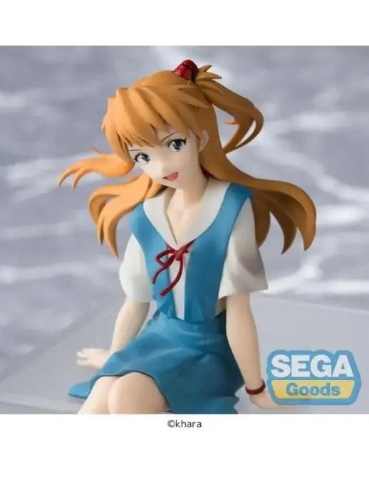 Figura da collezione di Asuka Shikinami Langley prodotta da Sega per la serie Evangelion, mostrata nel file oooo.jpg. La ragazza è seduta in uniforme scolastica azzurra e bianca mentre sorride, con i capelli ramati raccolti nei codini e le gambe che penzolano dal bordo di un cubo trasparente.