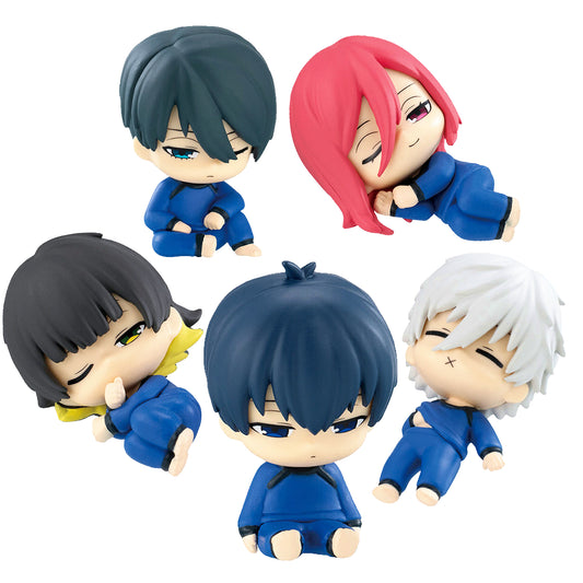 Set di cinque mini figure chibi gashapon della serie anime Blue Lock. I personaggi Isagi, Bachira, Chigiri, Nagi e Rin indossano le iconiche tute blu e sono ritratti in buffe pose assonnate, seduti o addormentati, su sfondo bianco.