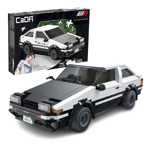 Il modello assemblato in mattoncini bianchi e neri della macchina Toyota AE86 Trueno della serie anime Initial D posizionato in primo piano, con la sua scatola originale CaDA visibile sullo sfondo nero che mostra l'auto in azione e il personaggio di Takumi Fujiwara.
