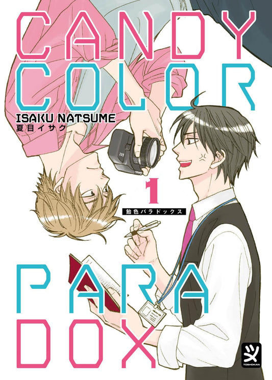 Copertina del manga Candy Color Paradox Vol. 1 edito da Toshokan. Un'illustrazione dal tratto pulito e vivace mostra i due protagonisti che si guardano. A destra, il cronista Satoshi Onoe, vestito con camicia bianca, cravatta rosa e gilet scuro, regge un taccuino e una penna guardando l'altro con un'espressione seccata ma partecipe. A sinistra, disegnato a testa in giù, il fotografo Motoharu Kaburagi indossa una camicia rosa e tiene in mano una macchina fotografica nera, sorridendo in modo sornione. Il tito