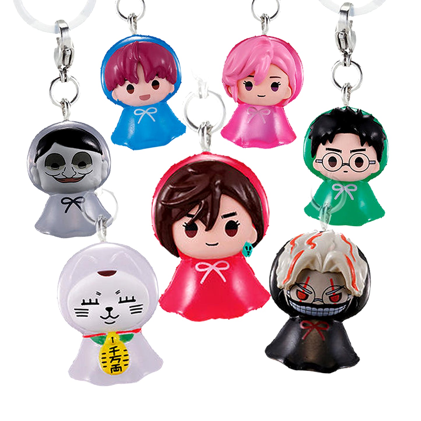 Immagine promozionale di 7 ciondoli gashapon della serie Dandadan su sfondo bianco, realizzati con un design a forma di piccoli fantasmini ("teru teru bozu") dotati di mantelline colorate e un fiocchetto al collo. Al centro spicca Momo Ayase con un mantello rosso; in alto da sinistra ci sono Jiji con mantello blu, Aira con mantello rosa e Okarun con mantello verde e occhiali. Ai lati e in basso troviamo i personaggi sovrannaturali.