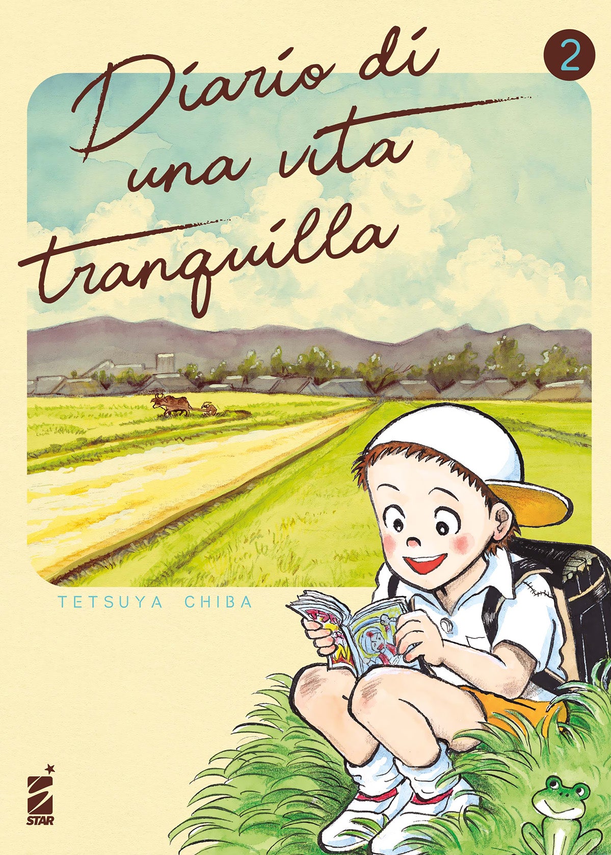 Copertina del secondo volume del manga Diario di una vita tranquilla, che mostra un bambino seduto su un prato d'erba verde mentre sfoglia un piccolo fumetto colorato, affiancato da un riquadro sullo sfondo che raffigura una distesa di campi e risaie ai piedi di una catena montuosa.