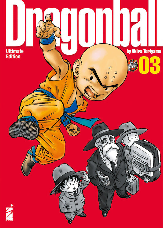 Copertina del manga Dragon Ball Ultimate Edition Vol. 3. Su uno sfondo rosso acceso, in primo piano spicca Crilin a colori, vestito con la tipica divisa da combattimento arancione, colto a mezz'aria in un balzo dinamico verso lo spettatore. In basso a destra, disegnati in bianco e nero, ci sono il Maestro Muten, Goku e lo stesso Crilin vestiti elegantemente con completi scuri, cravatta e cappello, intenti a trasportare i loro bagagli.