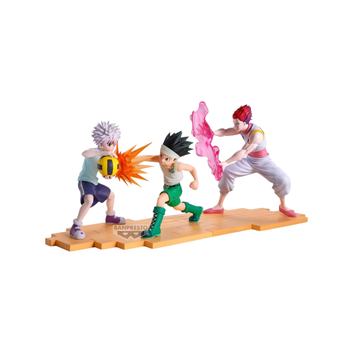 Set completo di figure da collezione in PVC di Gon (14 cm), Killua (15 cm) e Hisoka (18 cm) dall'anime 'Hunter x Hunter' durante l'arco di Greed Island, prodotte da Banpresto. La scultura forma un unico diorama su base mattonata arancione: Killua tiene saldamente la palla da dodgeball gialla e nera mentre Gon sferra un pugno carico d'energia con effetti d'impatto arancioni, affiancati da Hisoka che manipola la sua abilità Bungee Gum rosa traslucida.