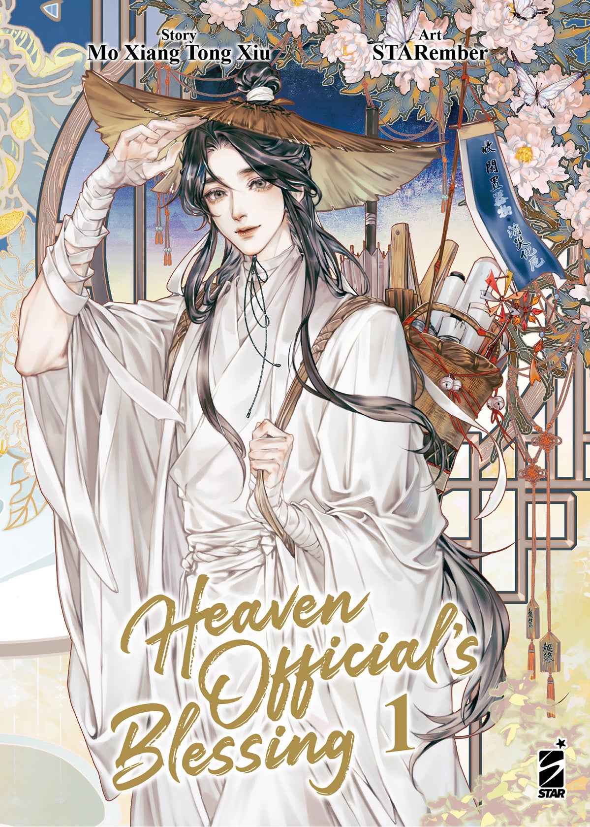 Copertina del manhua Heaven Official's Blessing Vol. 1, edito in Italia da Star Comics. L'illustrazione, dallo stile raffinato e ricco di dettagli, ritrae il protagonista Xie Lian in primo piano. È un giovane uomo affascinante dai lunghi e setosi capelli scuri, vestito con una morbida e candida veste tradizionale bianca. Con una mano, le cui braccia sono avvolte da bende bianche, solleva leggermente un ampio cappello di paglia dalla testa, rivolgendo un sorriso dolce e sereno allo spettatore. Sulle spalle p