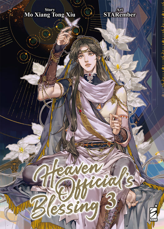 Copertina del manhua Heaven Official's Blessing volume 3. Splendida e dettagliata illustrazione di Xie Lian, vestito con eleganti abiti chiari e preziosi gioielli dorati, mentre fa posare una farfalla d'argento luminescente sulla sua mano, circondato da grandi gigli bianchi su un magico sfondo notturno.