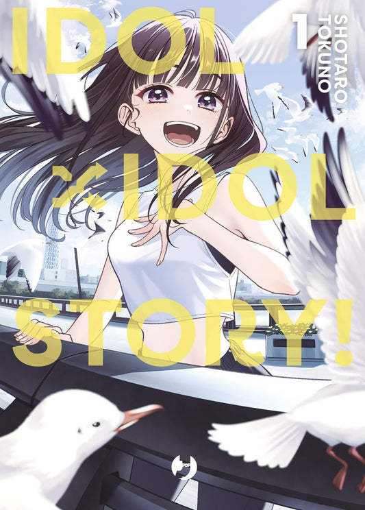 Copertina del manga Idol x Idol Story! volume 1. Un'illustrazione luminosa che ritrae in primo piano una ragazza molto sorridente dai lunghi capelli castani mossi dal vento, che indossa un top bianco sportivo. La ragazza è appoggiata a una ringhiera all'aperto, circondata da candidi gabbiani in volo sotto un cielo azzurro. Al centro, in grandi lettere gialle in sovrimpressione, campeggia il titolo dell'opera.