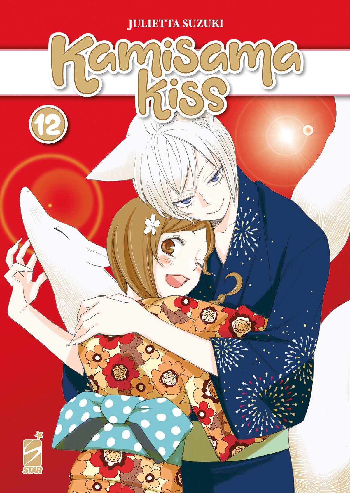 Copertina del dodicesimo volume in italiano del manga 'Kamisama Kiss' di Julietta Suzuki, edito da Star Comics. L'illustrazione su uno sfondo rosso acceso con bagliori di luce ritrae la protagonista Nanami sorridente in un kimono floreale arancione mentre viene abbracciata con tenerezza da Tomoe, con orecchie da volpe e vestito con un yukata blu scuro decorato con fuochi d'artificio, affiancati dal titolo Kamisama Kiss, dal numero 12 in alto a sinistra e dal logo Star Comics in basso a sinistra.