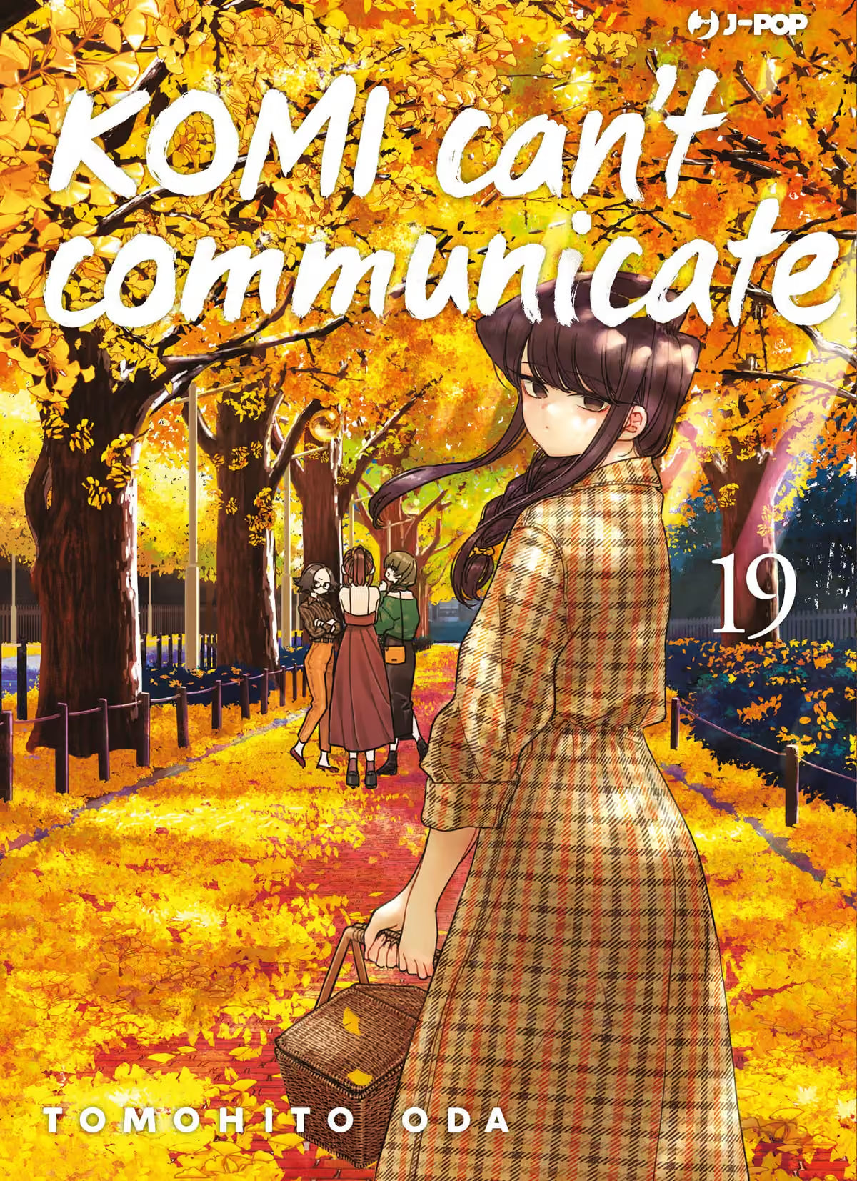 Copertina del diciannovesimo volume del manga 'Komi Can't Communicate' di Tomohito Oda, edito da J-POP Manga. L'illustrazione ritrae Shouko Komi in lungo abito a quadri marrone con un cestino in mano mentre si gira a guardare indietro lungo un viale alberato autunnale ricoperto di foglie dorate, sormontata dal titolo in bianco e dal numero 19 a destra.