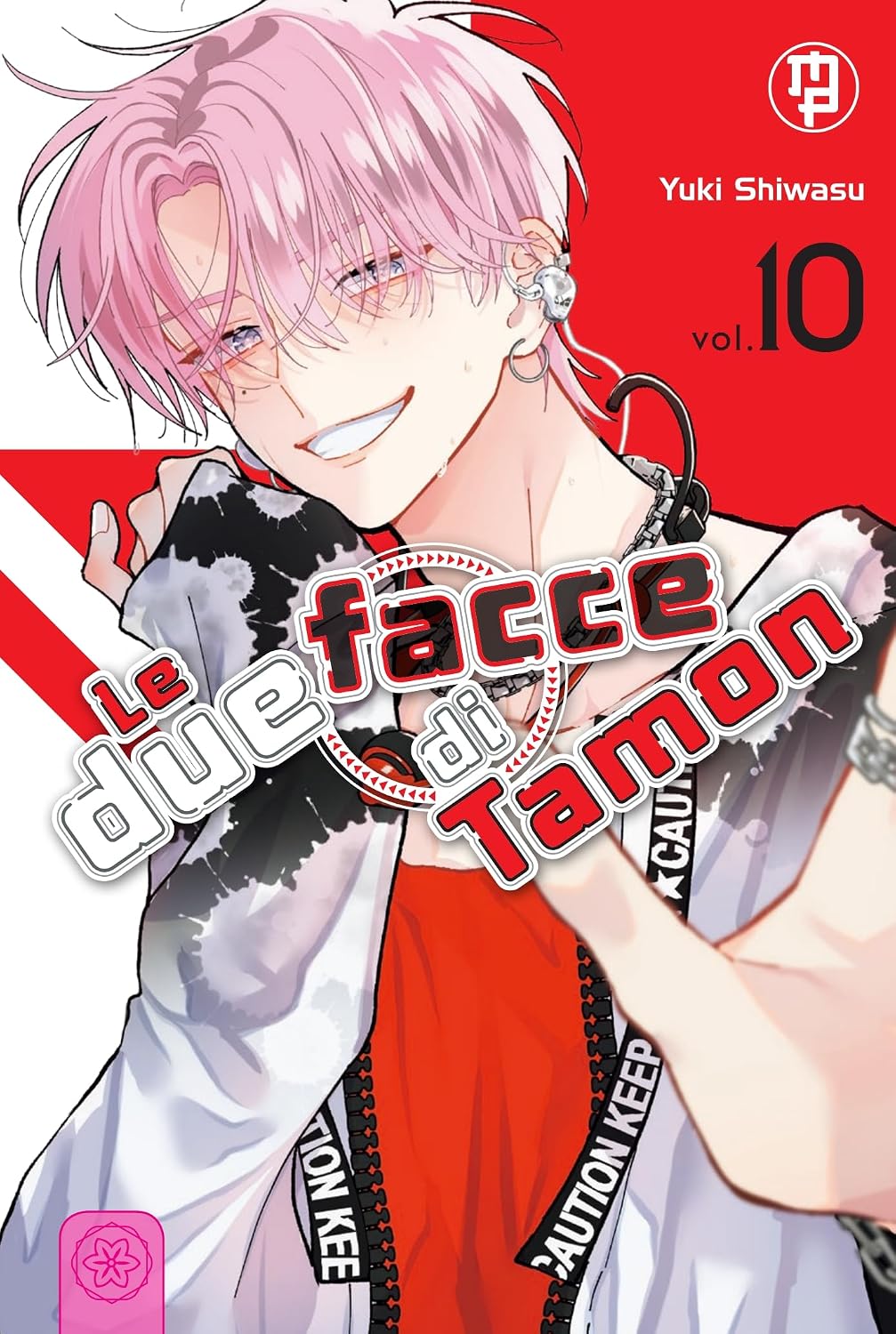 Copertina del decimo volume in italiano del manga 'Le Due Facce di Tamon' di Yuki Shiwasu, edito da Magic Press. L'illustrazione mostra in primo piano l'idol Tamon Fukuhara con i suoi capelli rosa acceso e gli occhiali da vista, mentre sfoggia un sorriso smagliante su uno sfondo geometrico rosso e bianco, vestito con una giacca bianca con macchie nere e una tracolla nera con scritte bianche.