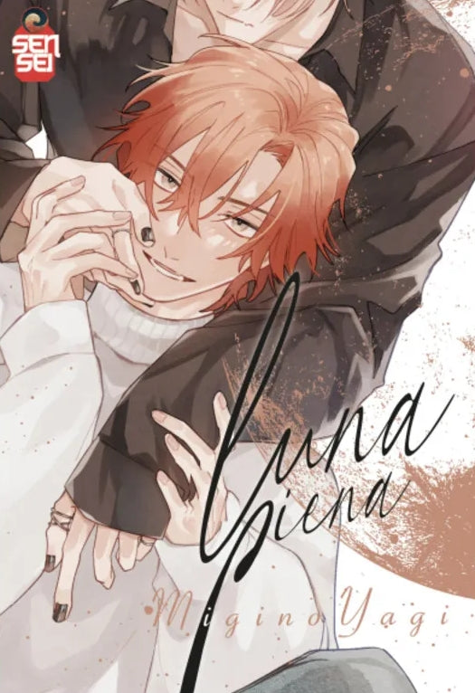 Copertina del manga Boys' Love 'Luna Piena' di Migino Yagi, edito da Manga Sensei. L'illustrazione ritrae in primo piano un giovane modello dai capelli arancione-ramati sorridente in maglione bianco, stretto dall'abbraccio da tergo di un altro ragazzo in camicia scura mentre si intrecciano le dita, con il titolo elegante in corsivo 'Luna Piena' e il logo Manga Sensei in alto a sinistra.