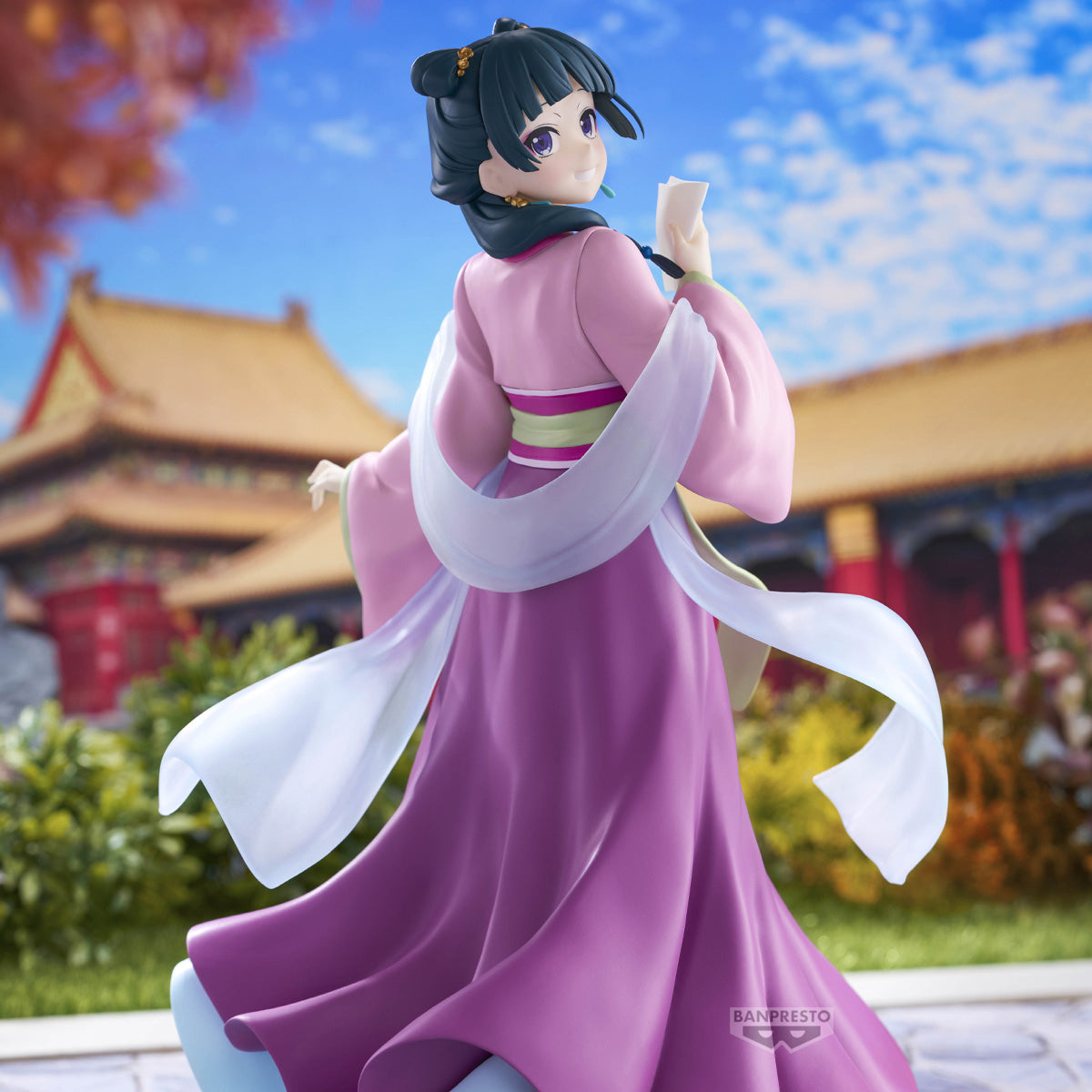 Figure di Maomao della serie The Apothecary Diaries prodotta da Banpresto. La ragazza indossa un elegante abito tradizionale rosa e viola, si volta sorridendo e tiene in mano un piccolo foglio.
