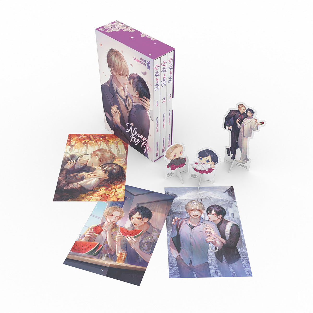Cofanetto da collezione Never Let Go. L'immagine mostra il box illustrato, i tre volumi del manga, tre illustration card a colori e tre standee dei personaggi.