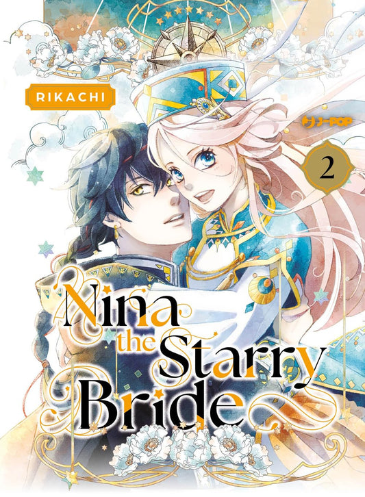 Copertina del manga Nina the Starry Bride volume 2. Un'illustrazione dallo stile acquerellato mostra un affascinante ragazzo dai capelli scuri e occhi dorati che abbraccia teneramente una ragazza dai lunghi capelli biondi e luminosi occhi azzurri. Indossano ricchi abiti tradizionali decorati in oro e blu, incorniciati da fiori bianchi, stelle e geometrie dorate.