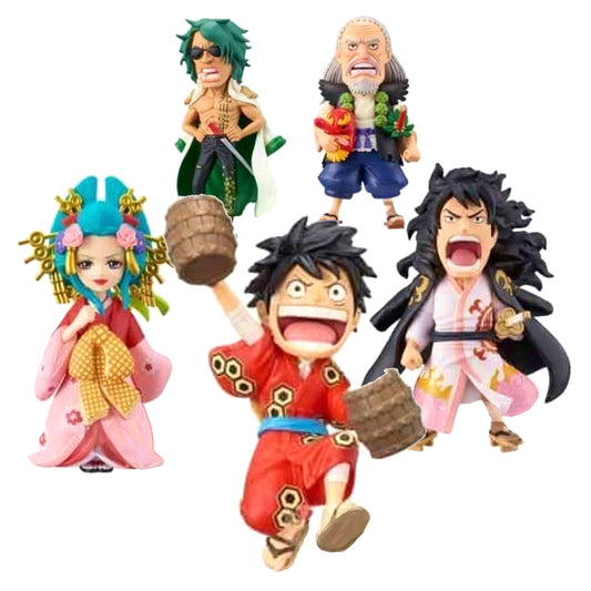 Immagine promozionale di 5 mini-figure della linea World Collectable Figure (WCF) di One Piece, dedicate alla conclusione dell'arco di Wano, disposte su sfondo bianco. In primo piano al centro c'è Luffy sorridente e festante con indosso un abito rosso, che solleva gioiosamente due piccoli barili di legno. A sinistra spicca l'elegante Komurasaki con un kimono rosa e rosso e un'elaborata acconciatura verde ricca di fermagli dorati. A destra si trova Kozuki Momonosuke in forma adulta.