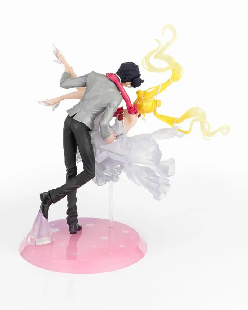 Figura da collezione di Sailor Moon e Tuxedo Mask della linea Figuarts Zero, visibile nel file vera.jpg. I due personaggi sono ritratti in un romantico passo di danza, con Tuxedo Mask in smoking grigio che solleva Sailor Moon, la quale indossa un sontuoso abito bianco fluttuante dalla finitura perlata.