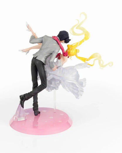Figura da collezione di Sailor Moon e Tuxedo Mask della linea Figuarts Zero, visibile nel file vera.jpg. I due personaggi sono ritratti in un romantico passo di danza, con Tuxedo Mask in smoking grigio che solleva Sailor Moon, la quale indossa un sontuoso abito bianco fluttuante dalla finitura perlata.