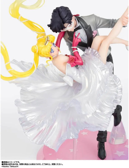 Figura da collezione di Sailor Moon e Tuxedo Mask della linea Figuarts Zero, visibile nel file vera.jpg. I due personaggi sono ritratti in un romantico passo di danza, con Tuxedo Mask in smoking grigio che solleva Sailor Moon, la quale indossa un sontuoso abito bianco fluttuante dalla finitura perlata.