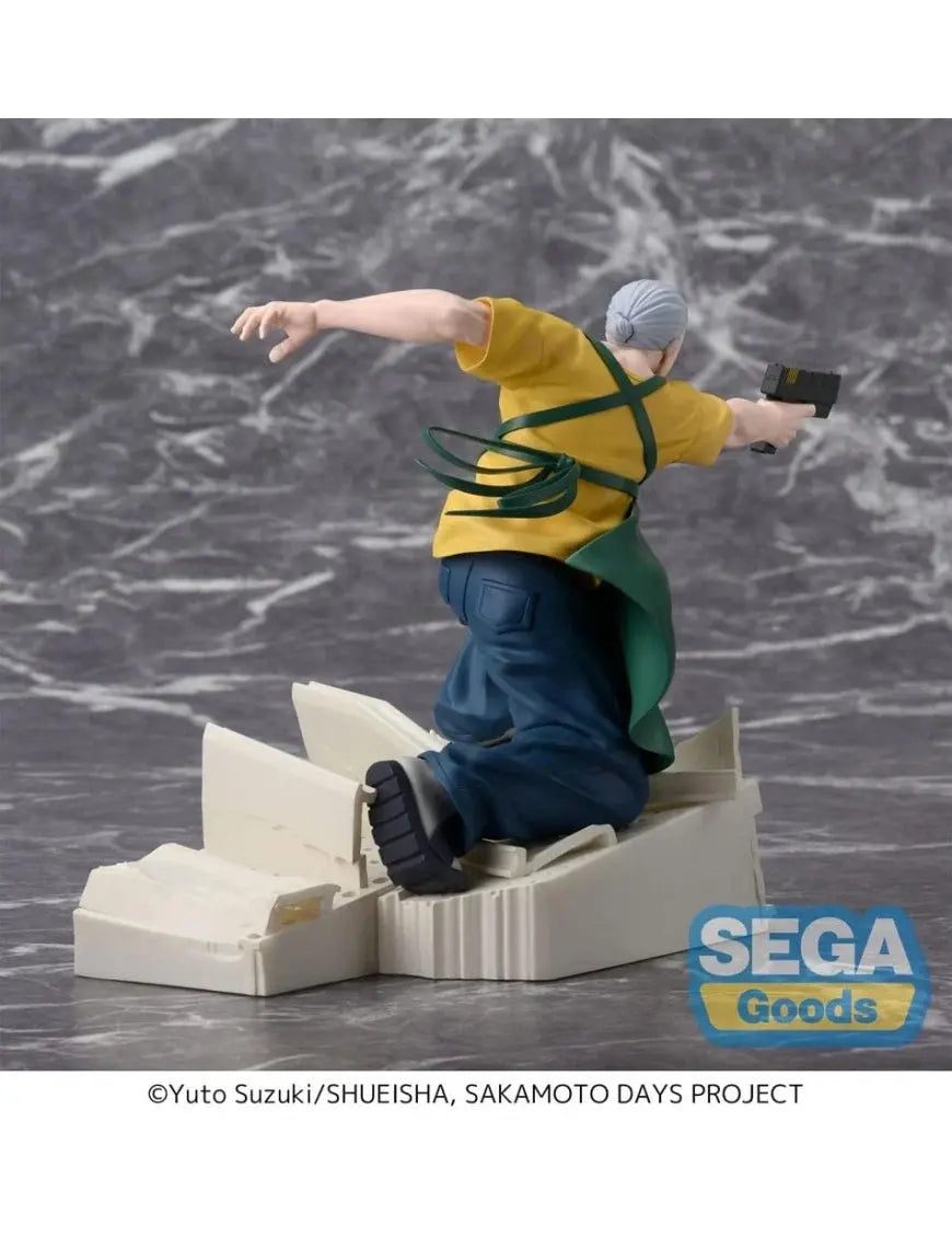 Figura da collezione di Taro Sakamoto nella sua forma magra da combattimento, tratta dal manga Sakamoto Days. Il personaggio indossa un grembiule verde sopra una maglietta gialla e pantaloni blu, mentre punta una pistola nera scivolando su macerie bianche.