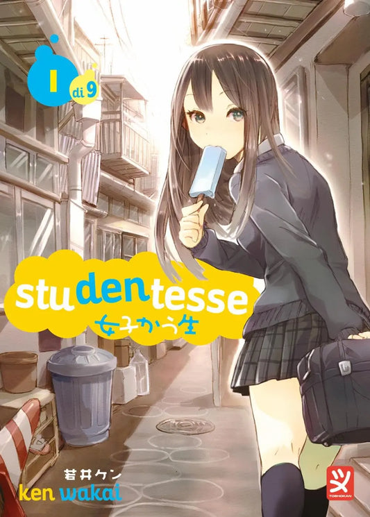 Copertina del manga Studentesse Vol. 1 edito da Toshokan; una ragazza in divisa scolastica con lunghi capelli castani cammina in un vicolo soleggiato mangiando un ghiacciolo azzurro.
