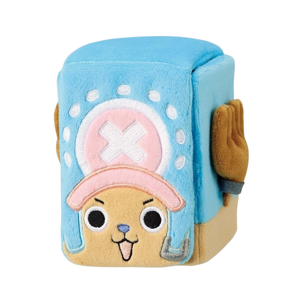 Deckbox in morbido peluche a forma di cubo dedicato a Tony Tony Chopper di One Piece, mostrato sia chiuso che aperto su sfondo nero. Da chiuso, la patta frontale mostra il viso ricamato di Chopper felice e il suo tipico cappello azzurro con visiera rosa e croce bianca. Dai lati del cubo spuntano delle graziose orecchie e un paio di corna marroni tridimensionali. Da aperto, la patta superiore è sollevata rivelando l'interno azzurro e il sistema di chiusura a strappo.