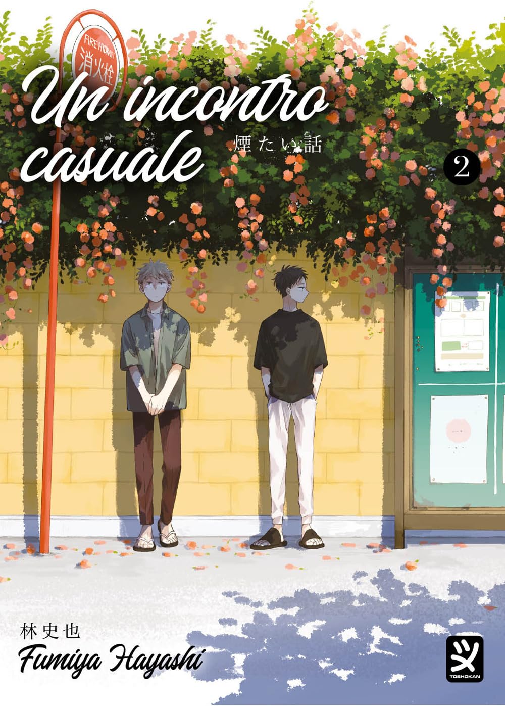 Copertina del manga Un Incontro Casuale Vol. 2; due ragazzi, uno con capelli chiari e l'altro scuri, stanno in piedi l'uno di fronte all'altro davanti a un muro giallo ricoperto da piante rampicanti e fiori arancioni, accanto a un palo rosso.
