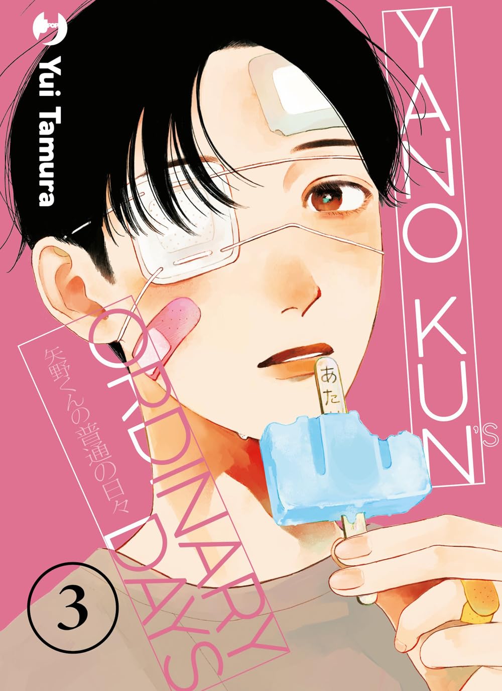 Copertina del manga Yano-Kun's Ordinary Days 3. Un ragazzo dai capelli scuri mangia un ghiacciolo azzurro su uno sfondo rosa. Il suo viso è pieno di cerotti e porta una vistosa benda sull'occhio destro.